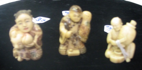 Appraisal: THREE IVORY HAND CARVED NETSUKE man with basket figure holding