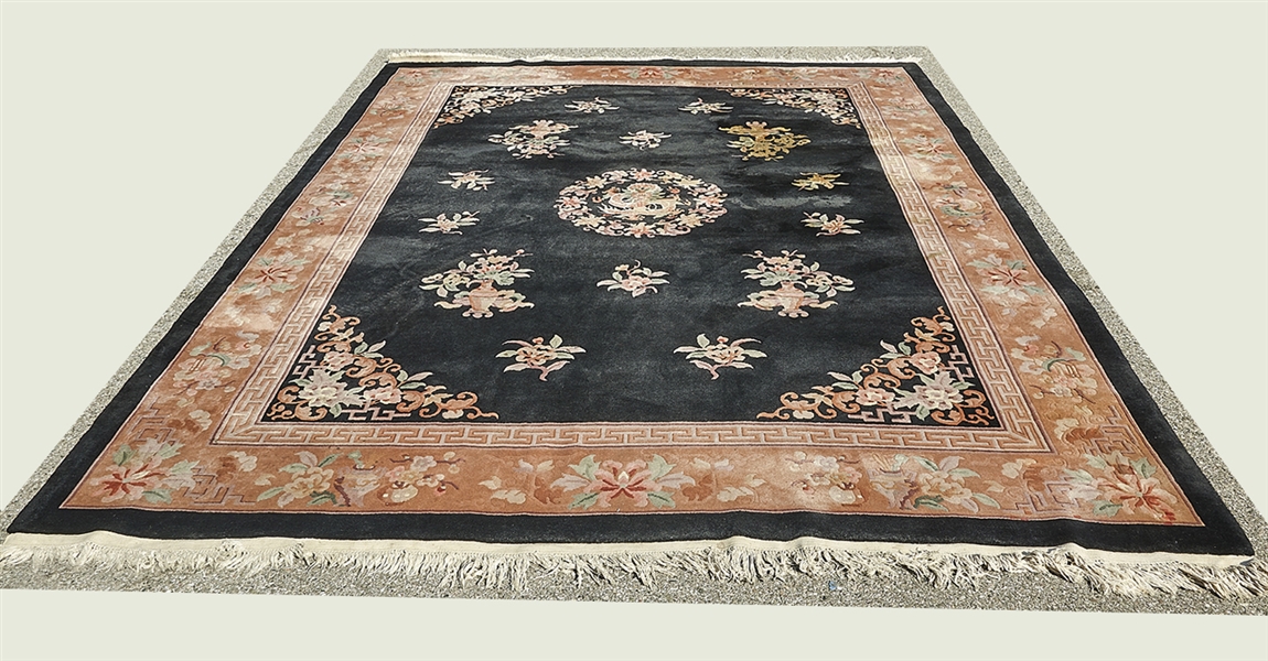 Appraisal: Black Chinese wool rug with dragon and floral central medallion