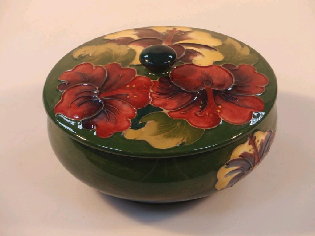 Appraisal: A Moorcroft circular squat bowl and cover decorated with lilies