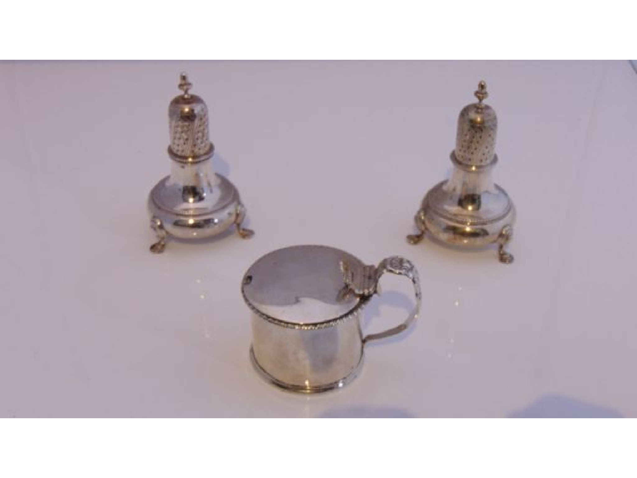 Appraisal: A pair of George V silver pepper casters possibly T