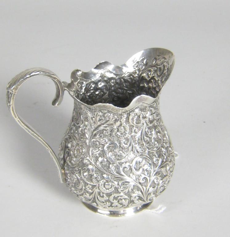 Appraisal: An Indian silver Cream Jug with floral and leafage scroll