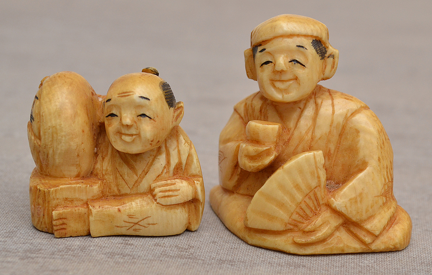 Appraisal: TWO IVORY NETSUKES MAN WITH FAN AND MAN WITH BABY