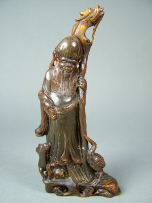 Appraisal: A Chinese carved horn figure of Shou-hsing holding a dragon