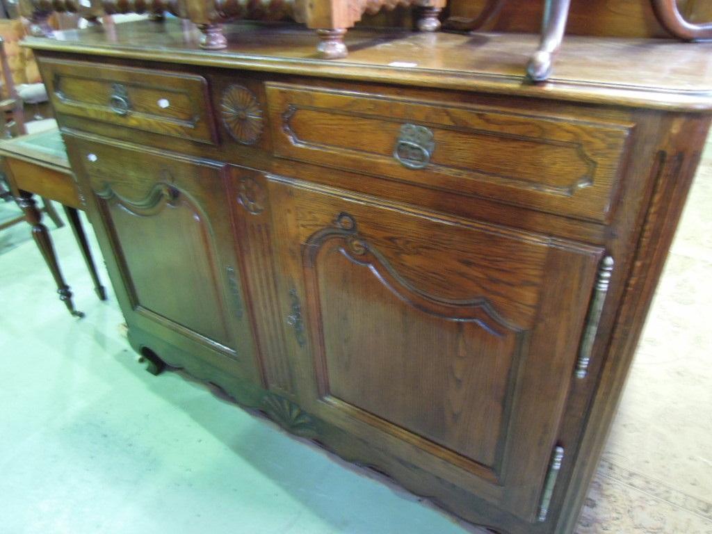 Appraisal: A French oak side cupboard fitted with two frieze drawers