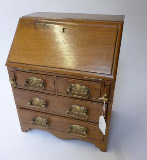 Appraisal: A MINIATURE OAK BUREAU early th century the fall front