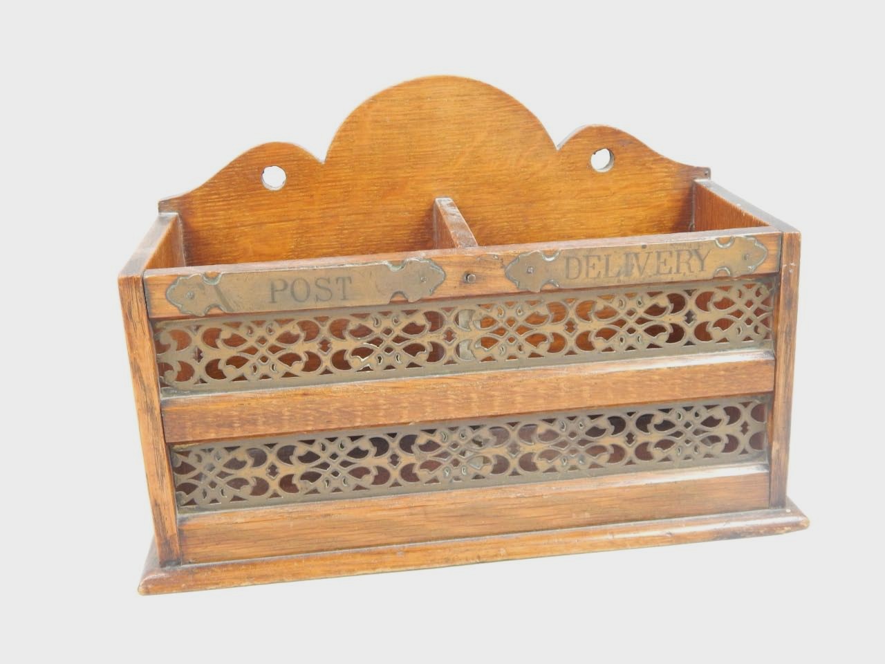 Appraisal: An Edwardian oak letter rack with pierced brass grills and