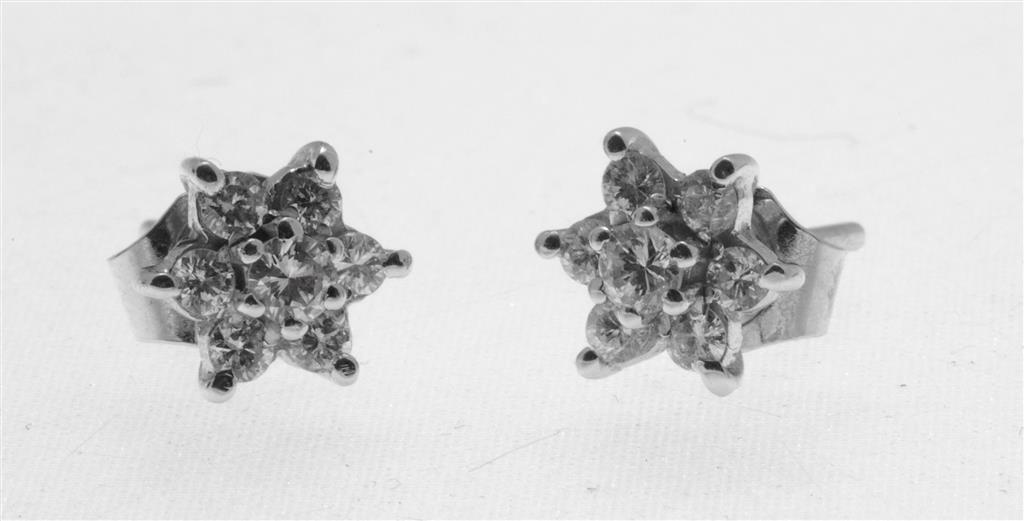 Appraisal: A pair of diamond cluster earrings each set with seven