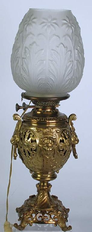 Appraisal: ORNATE BRASS OIL TABLE LAMP AND SHADE the ovular body