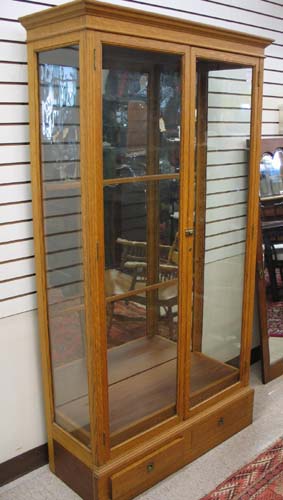 Appraisal: A TALL OAK AND GLASS DISPLAY CABINET American late th