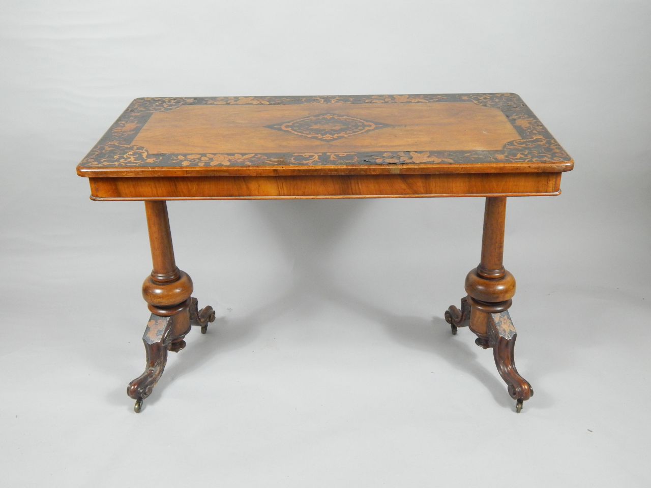 Appraisal: A Victorian walnut and marquetry inlaid library table the quarter