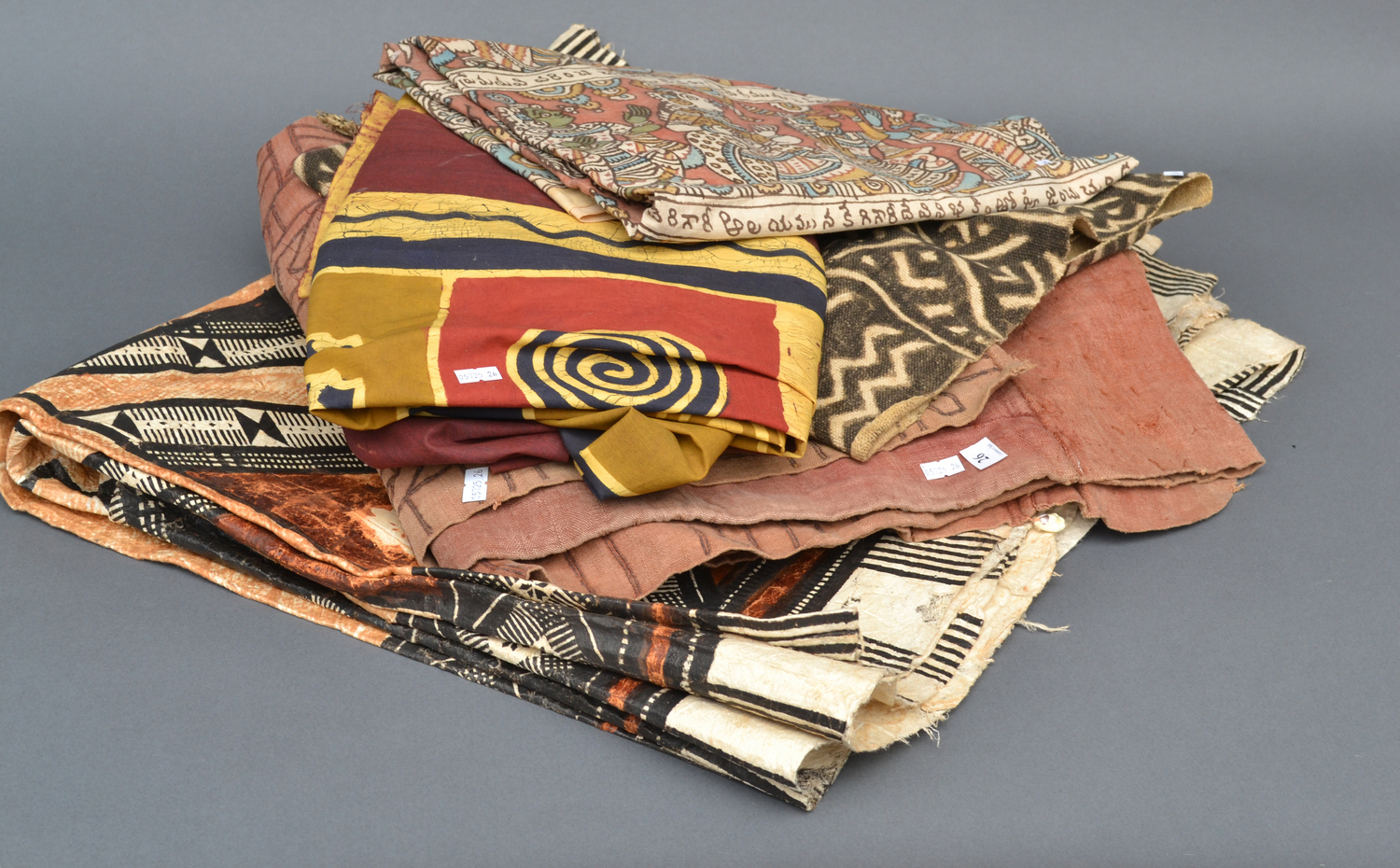 Appraisal: FOUR TRIBAL CLOTHS AND A TAPA CLOTH