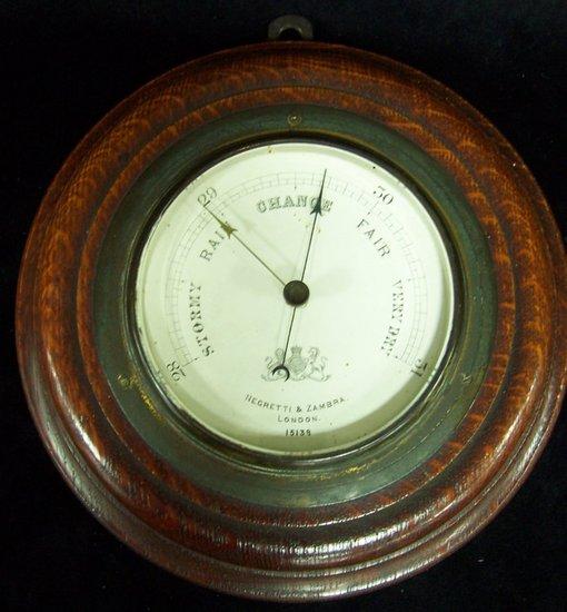 Appraisal: A small circular barometer by Negretti Zambra in an oak