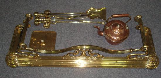 Appraisal: A brass Art Nouveau fender together with brass fire irons