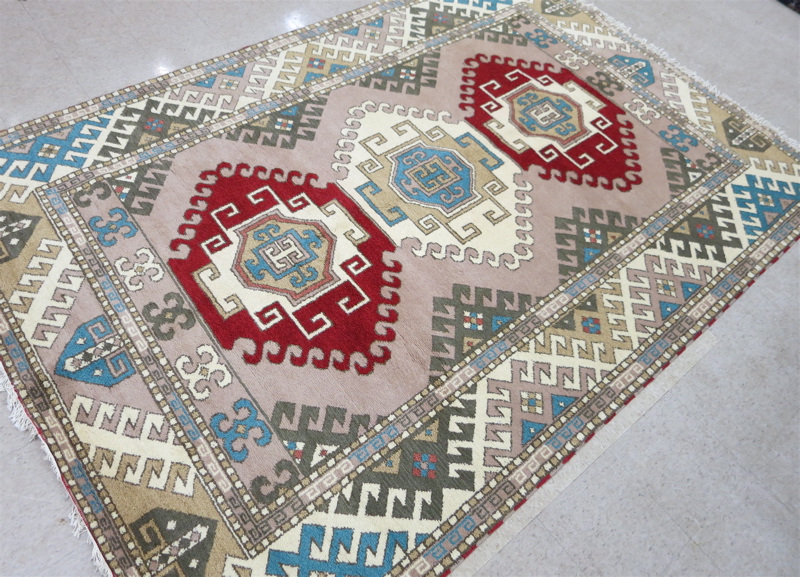 Appraisal: HAND KNOTTED ORIENTAL CARPET Indo-Kazak three geometric medallion design on