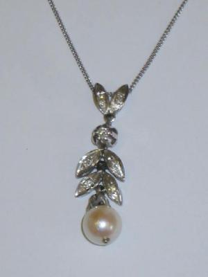 Appraisal: A CULTURED PEARL AND DIAMOND PENDANT comprising a line of