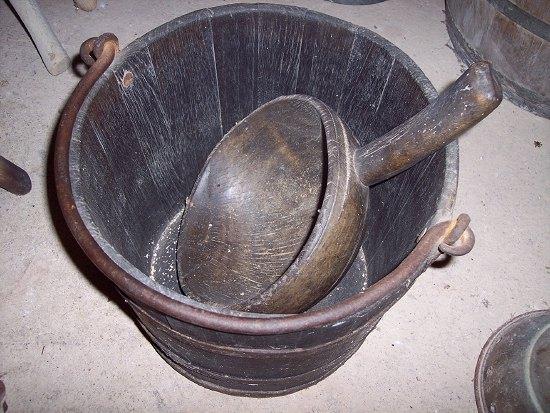 Appraisal: A carved wood scoop and a metal bound bucket