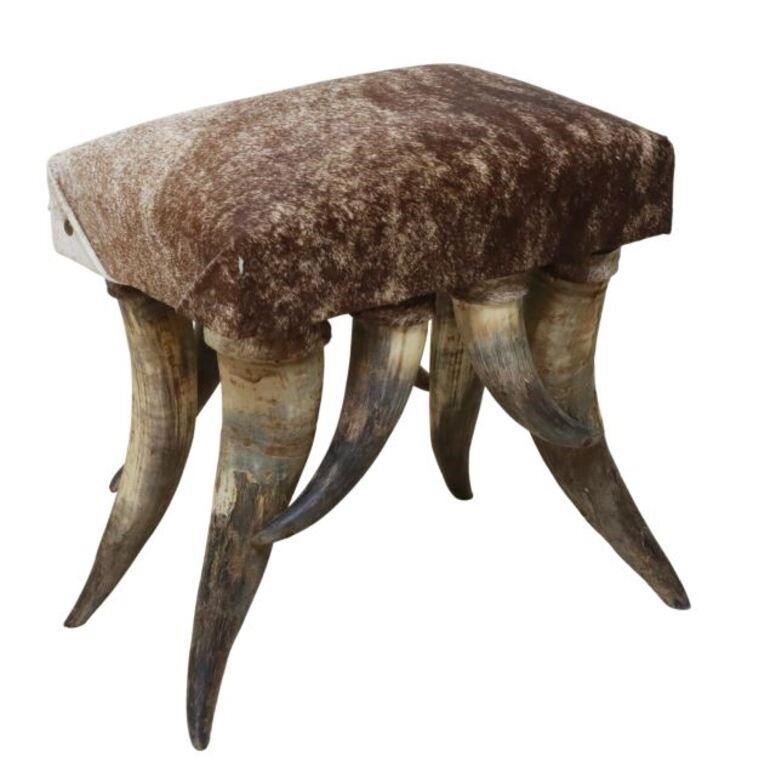 Appraisal: Western cowhide upholstered ottoman with nailhead tacks at corners rising