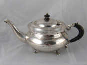 Appraisal: A white metal tests silver teapot on four feet of