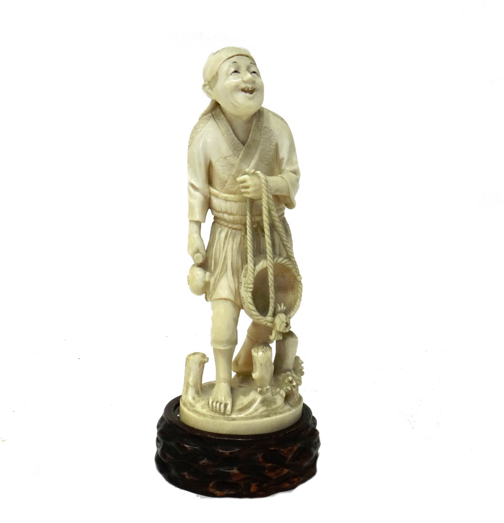 Appraisal: A Japanese ivory okimono of a fisherman Meiji period standing