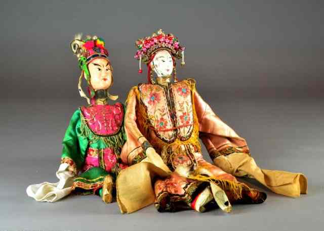 Appraisal: Chinese Wooden Dolls with CostumesTwo dolls having handpainted faces and