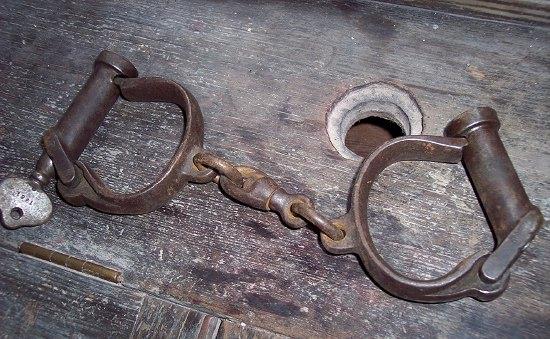 Appraisal: A pair of iron handcuffs with key the key marked