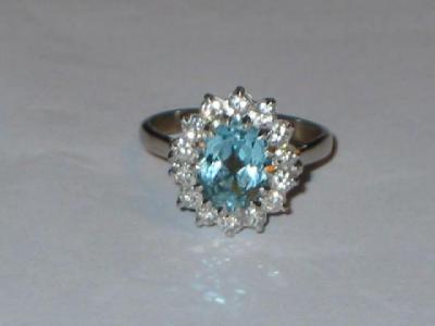 Appraisal: AN AQUAMARINE AND DIAMOND CLUSTER RING the oval cut aquamarine