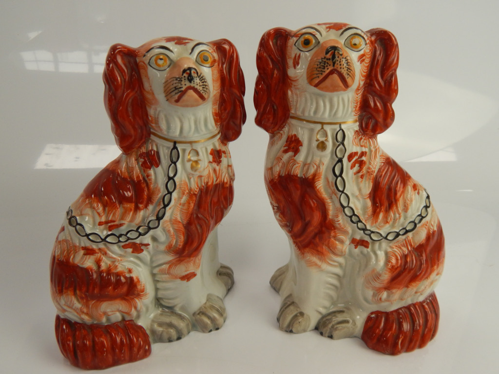 Appraisal: A composite pair of late Victorian Staffordshire seated spaniel comforter