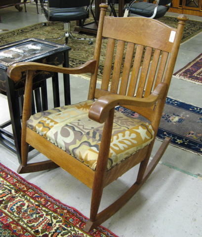 Appraisal: AN OAK SLAT-BACK ROCKING ARMCHAIR American c with seven vertical