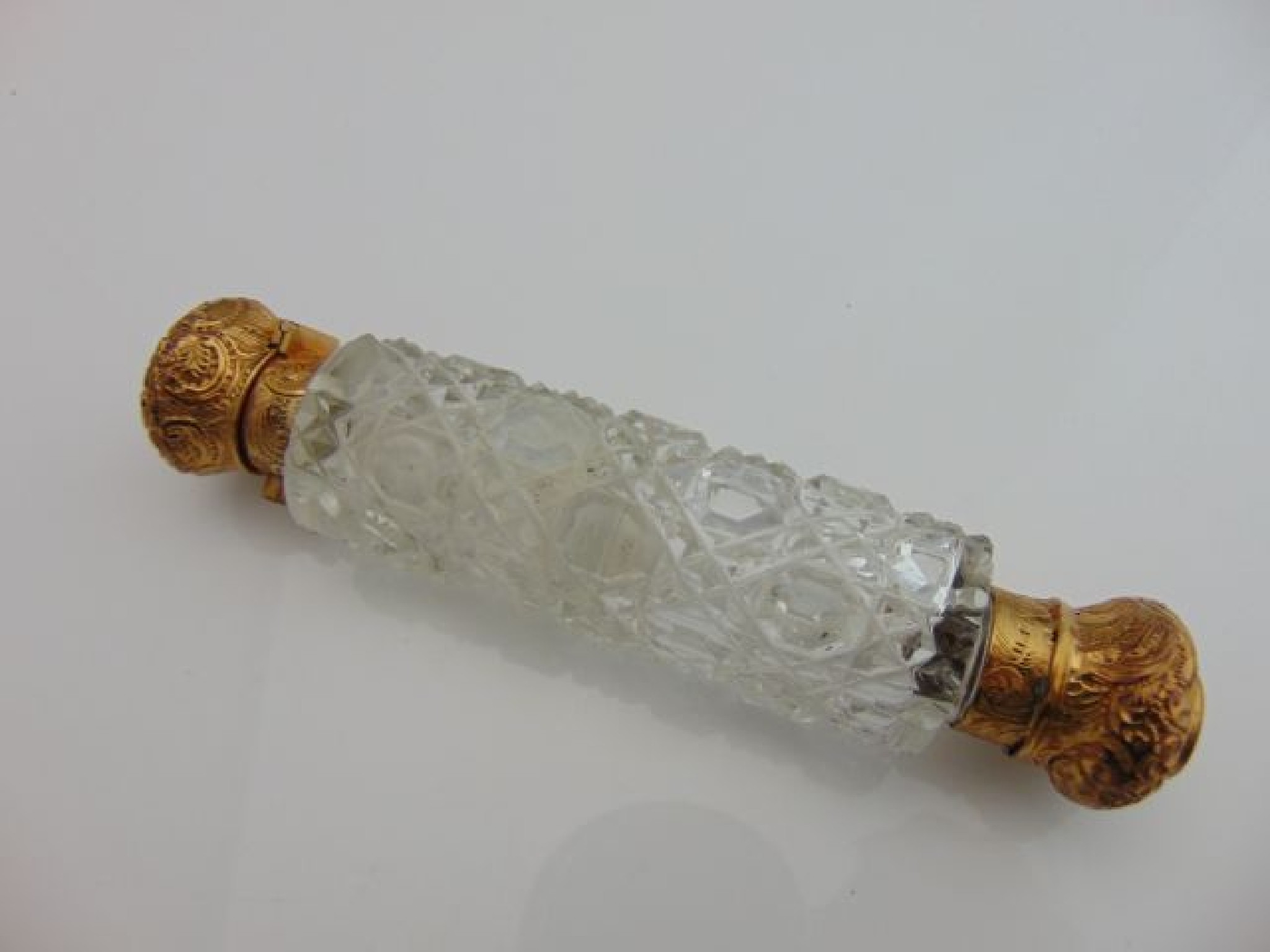 Appraisal: A double-ended scent bottle with embossed gilt covers cut-glass body