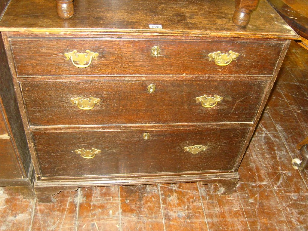 Appraisal: A Georgian oak chest of three long graduated drawers on