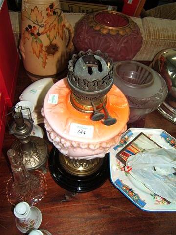 Appraisal: A Victorian oil lamp with orange glass reservoir two oil