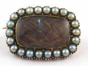 Appraisal: An antique gold mourning brooch with locket compartment containing plaited