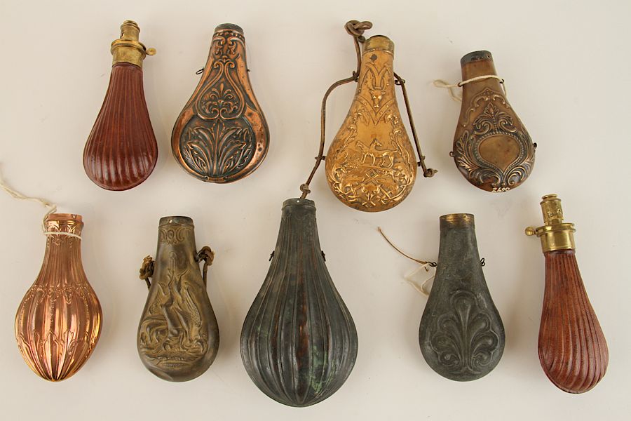 Appraisal: COLLECTION OF NINE GUNPOWDER FLASKS A collection of nine gunpowder