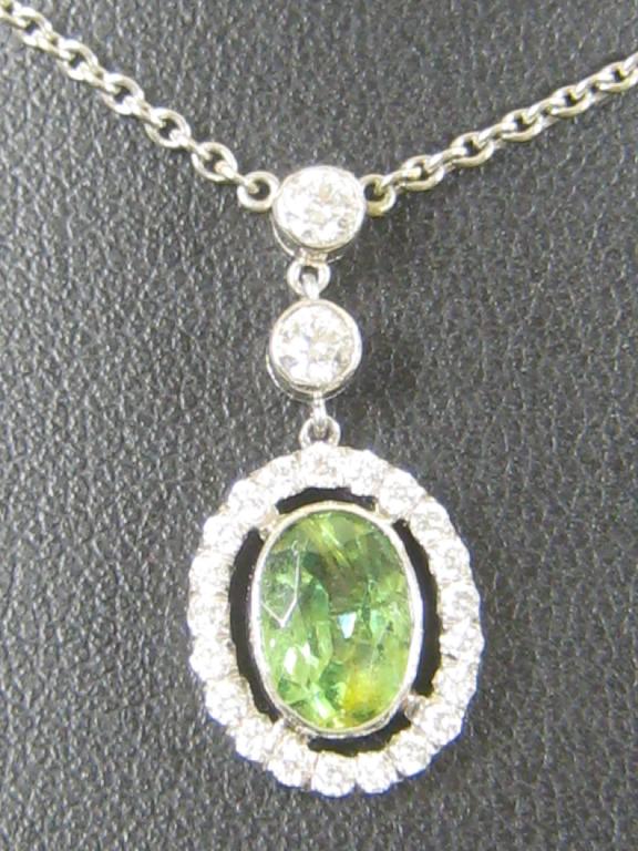 Appraisal: A demantoid garnet and diamond Pendant the oval shaped garnet