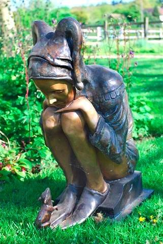 Appraisal: A bronze statue of a girl in pixie costume sitting