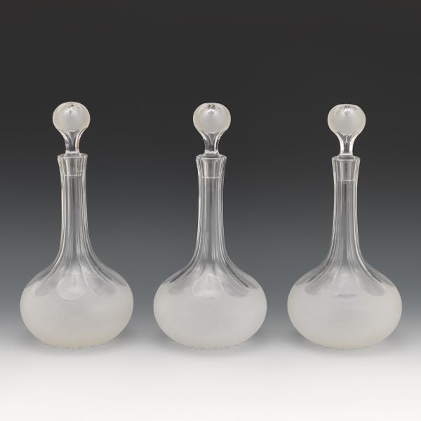 Appraisal: THREE GLASS CUT BACK AND FROSTED DECANTERS WITH STOPPERS each