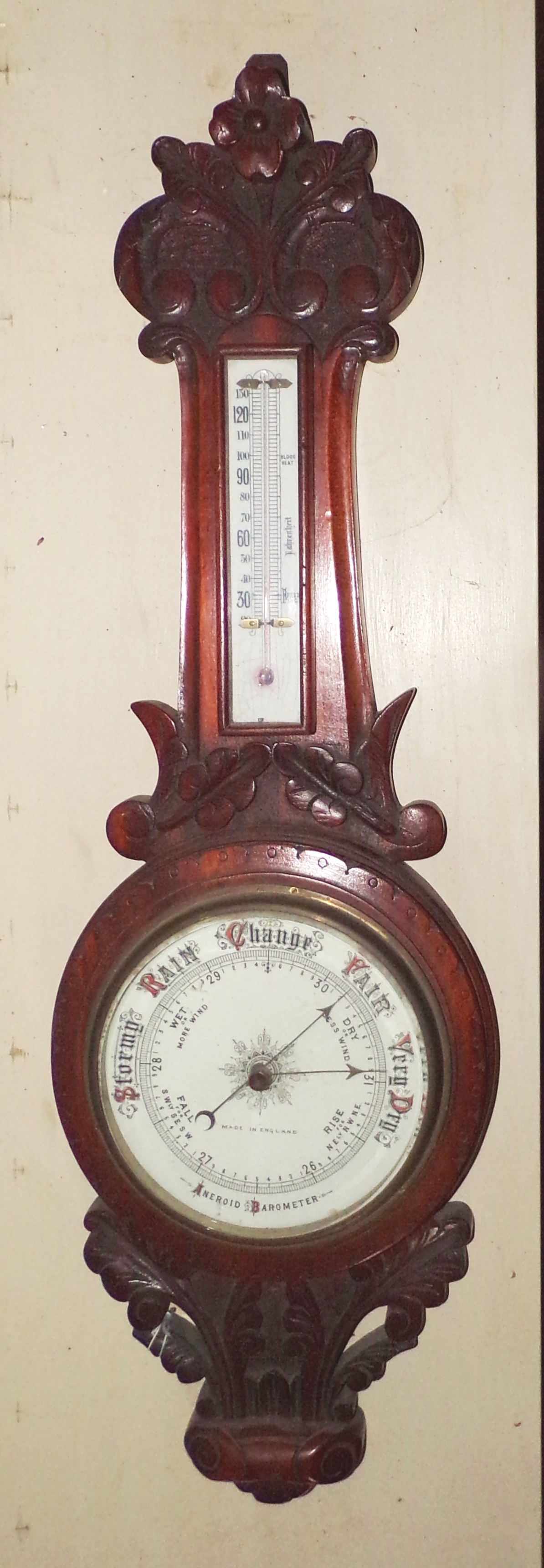 Appraisal: English aneroid barometer set in a carved wood surround ''