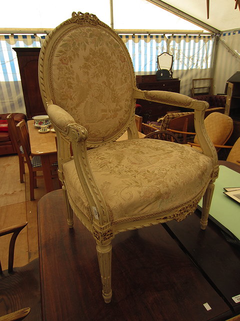 Appraisal: A GREEN PAINTED FRENCH STYLE ARMCHAIR ribbon tied crest inset