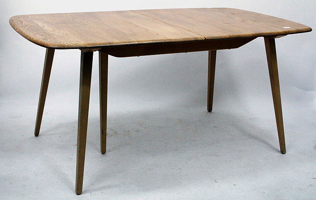 Appraisal: AN ERCOL TYPE LIGHT ELM EXTENDING DINING TABLE the shaped