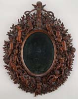 Appraisal: AN EXTRAORDINARY CARVED OAK OVAL WALL MIRROR Surrounded by relief