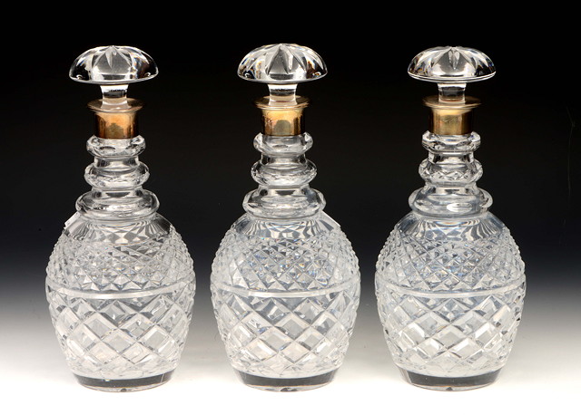 Appraisal: A SET OF THREE CUT GLASS DECANTERS with silver mounted