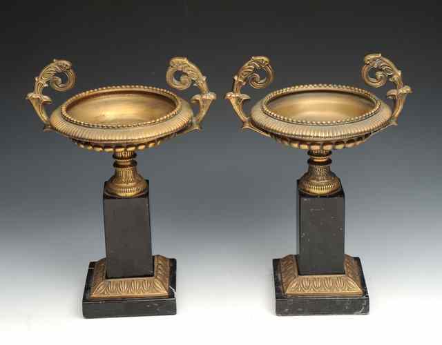 Appraisal: A PAIR OF BRASS TAZZA with scrolling handles an on