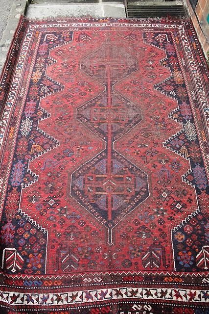 Appraisal: A CAUCASIAN RED GROUND RUG with central panels within a