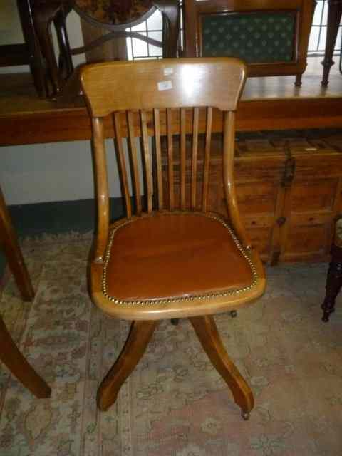 Appraisal: AN EDWARDIAN WALNUT SWIVEL OFFICE CHAIR with quadruped base