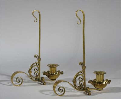 Appraisal: A pair of brass candlesticks scrolling form with floriform sconce