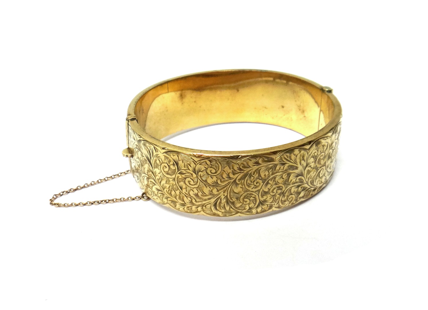 Appraisal: A ct gold oval hinged bangle the front with feathered