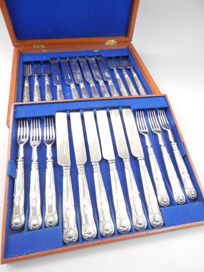 Appraisal: A canteen of cutlery with silver shell capped handles and