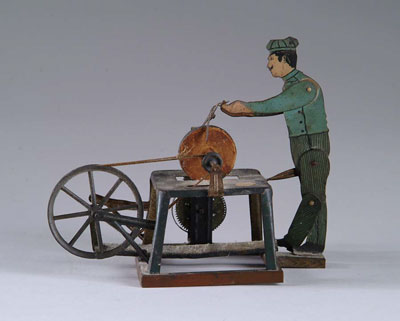 Appraisal: WORKER AT GRINDING WHEEL Tin wind-up Germany Flat tin lithograph