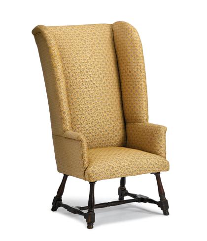 Appraisal: Upholstered wingback chairThe tall back with arched wings and slightly