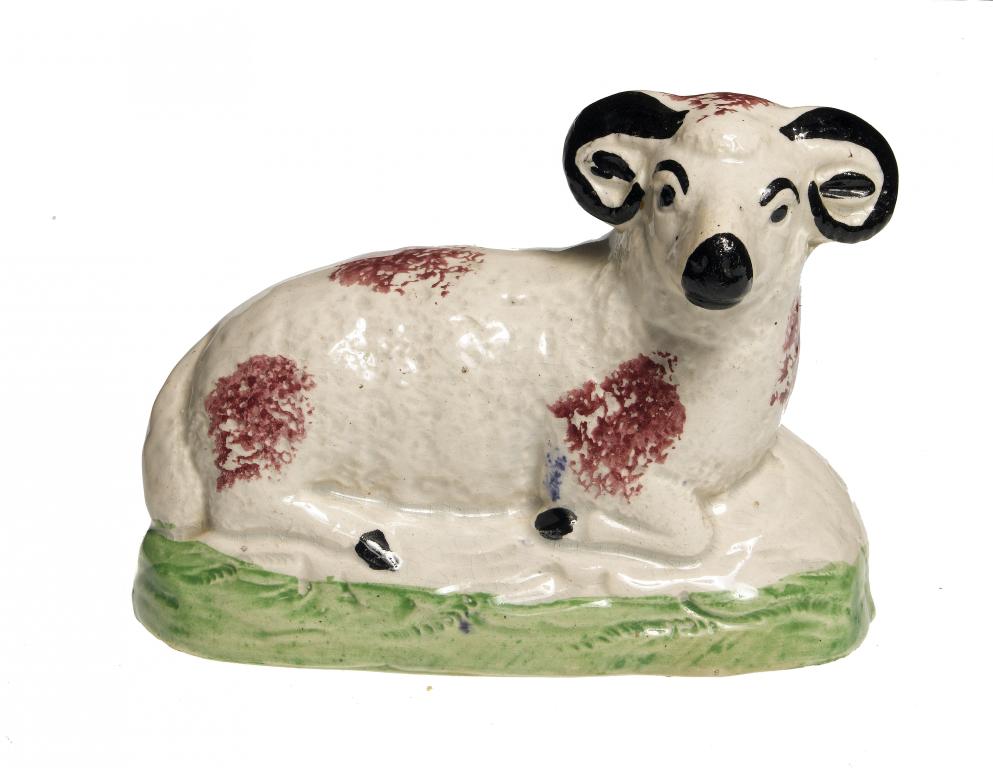 Appraisal: A PEARLWARE MODEL OF A RECUMBENT RAM sponged with puce